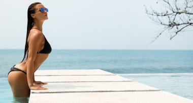 Tatili boyunca havuzda dinlenen seksi kadın.