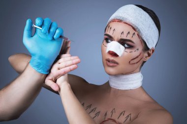 Plastik cerrahi kurbanlarının kavramsal görüntüsü. Yara ve bandajla sarılmış bir kadın başka bir ameliyat için hazırlanıyor..