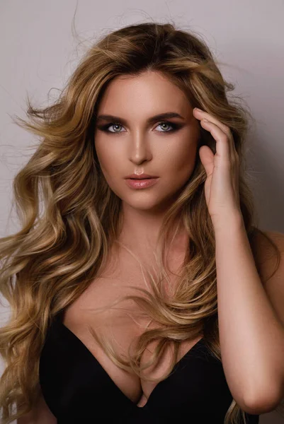 Güzel kıvırcık saçlı ve profesyonel makyajlı muhteşem bir kadının portresi.