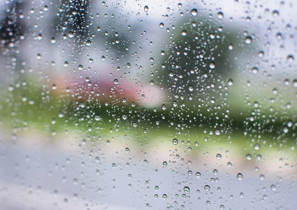 Rain water drops and  text on window with  abstract blur background. (vintage)