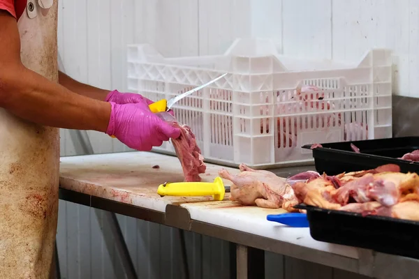 Carnicero en delantal blanco picando carne de pollo. Tienda de corte del mercado agrícola . — Foto de Stock
