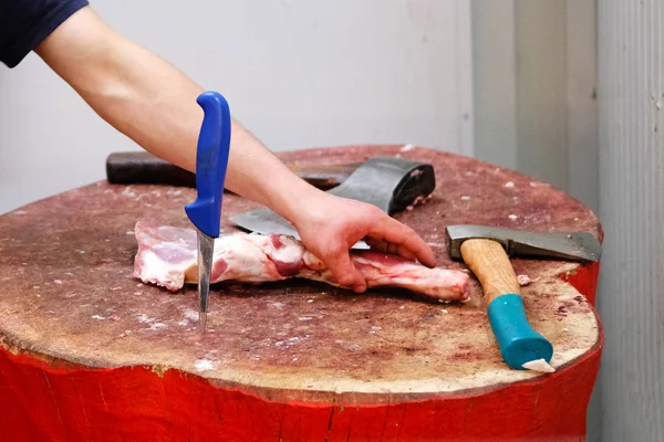 Carnicero chuletas de carne fresca en el registro de madera de la tienda de corte en el mercado agrícola. Herramientas para carniceros cuchillo y hachas . — Foto de Stock