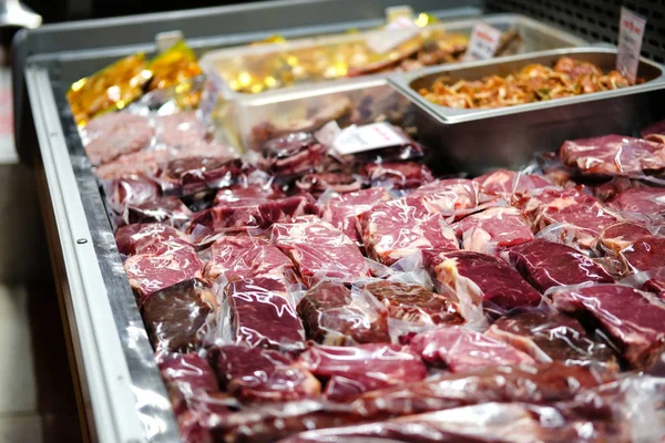 Carne de res, ternera, cordero fresco filetes crudos se envasan al vacío y se venden en el mostrador de la tienda . — Foto de Stock