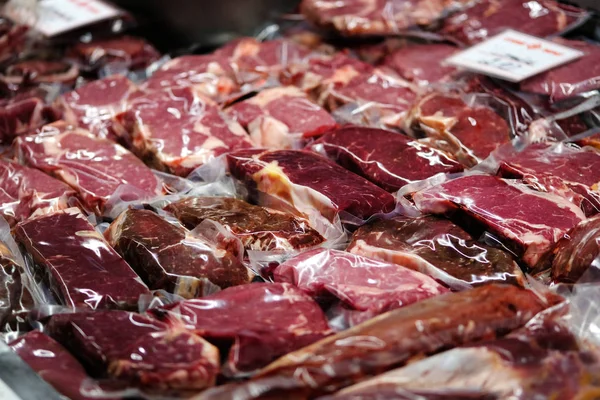 Carne de res, ternera, cordero fresco filetes crudos se envasan al vacío y se venden en el mercado . — Foto de Stock