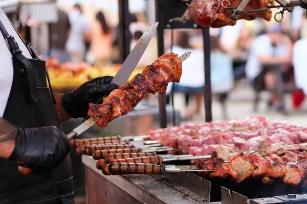 Şef ızgara et kızartma. Siyah önlük patates ateş et pişirmek. Açık havada barbekü. Parlak bokeh.