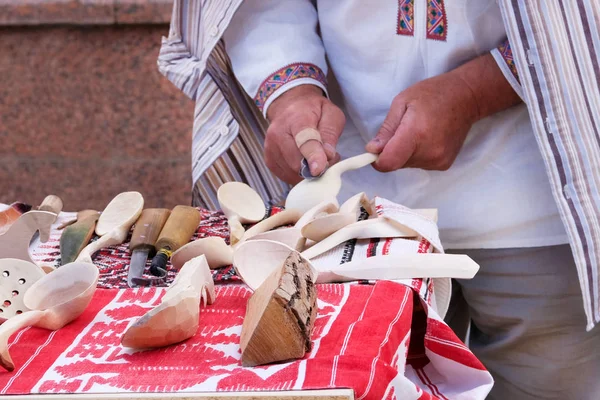 Řemeslník ukazuje proces tvorby vařečky ručně pomocí nástrojů. Koncepce národní řemesla. — Stock fotografie