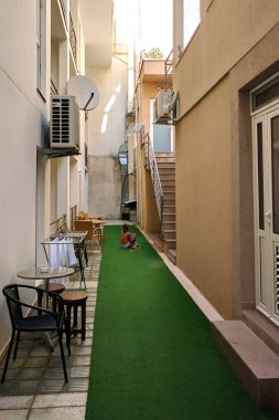 Llittle kız arasında dar bir bahçede katta oturan ev sahipliği yapmaktadır. Karadağ'daki yaz.