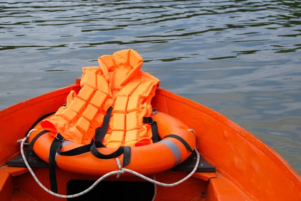 Outfit of lifeguard on water in summer boat, life jacket, lifebuoy in orange color. Rescue on water in summer concept. — Stock Photo, Image