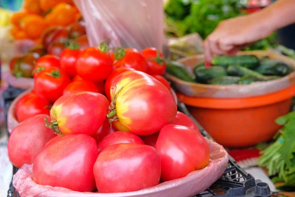 Roze grote tomaten worden verkocht tegen lokale groente landbouw markt. Rundvlees hart tomaten verkoop na de oogst. — Stockfoto