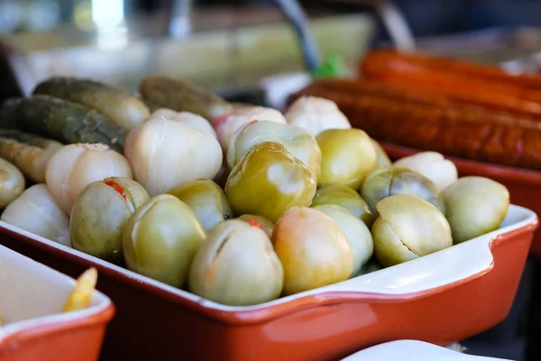 Ingemaakte groene tomaten, komkommers en knoflook in de vleesmarkt in de straat. Straatvoedsel en outdoor cooking concept — Stockfoto