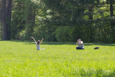 Park'ın bahçesinde kız resimleri alarak genç adam. Genç tatil yaz parkta çift..