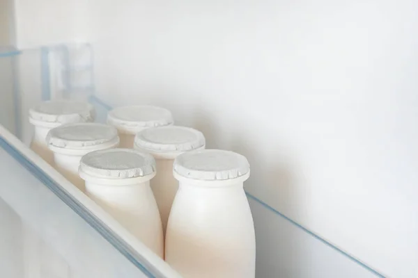 Botellas blancas de productos lácteos en el estante del refrigerador vacío abierto. concepto de dieta de pérdida de peso . — Foto de Stock