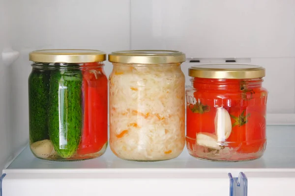 Os jarros de várias verduras conservadas em escabeche estão no refrigerador. Conceito de alimento natural saudável fermentado . — Fotografia de Stock