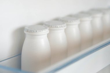 Yoğurt açık boş buzdolabı rafındaki beyaz şişe. Kilo kaybı diyet kavramı.