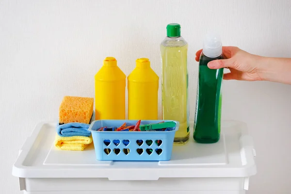 Концепция очистки. Средство для уборки помещений. Пластиковые бутылки с моющим средством и салфетками из микроволокна. Горничная или домохозяйка заботится о доме . — стоковое фото