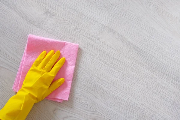 Ofis, ev temizlik kavram. Sarı kauçuk koruyucu eldiven mikro fiber bez ile elinde ahşap zemin temizlik olduğunu. Kopya alanı. — Stok fotoğraf