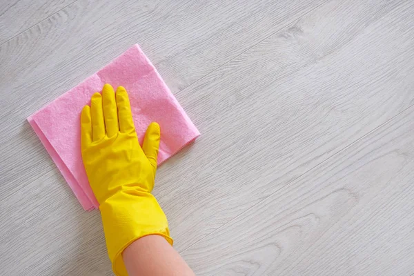 清洁概念在办公室, 家庭。女性手与粉红色的抹布是擦拭浅色木地板在家里。家务和家政概念. — 图库照片