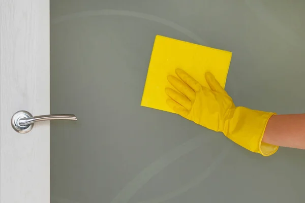 在家中的清洁理念。女性手与黄色抹布正在擦拭玻璃门在家里。家务和家政概念. — 图库照片