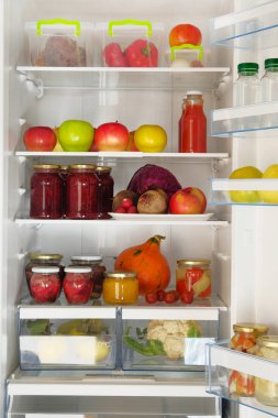 Çeşitli cam ev yapımı meyve ve meyve reçel, meyve suları ve taze sebze ve meyveler buzdolabında rafta kavanozları. Fermente sağlıklı Vejetaryen yiyecekler.