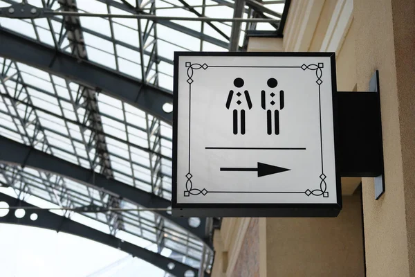 Sign of toilet made in modern style give direction to WC in shopping center. Vertical view. — Stock Photo, Image