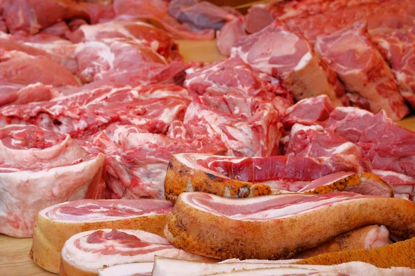 El tocino, la carne de cerdo y la manteca de cerdo se venden en el mercado local. Carne fresca cruda en mostrador . — Foto de Stock