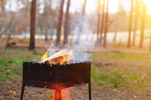 Flammen, brennendes Holz und Rauch aus nächster Nähe. Grillsaison in der Natur im Frühling geöffnet. Sonnenschein. — Stockfoto