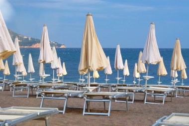 Deniz plaj birçok güneş şemsiyeleri ve sandalyeler turistler için bekliyor. Mutlu yaz tatil kavramı. Güneşli yaz plaj.