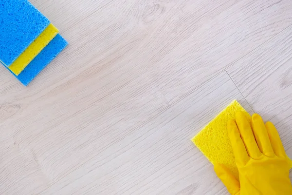 顶部视图。在家里用抹布清洗镶木地板的黄色橡胶保护手套。家务和家政概念. — 图库照片