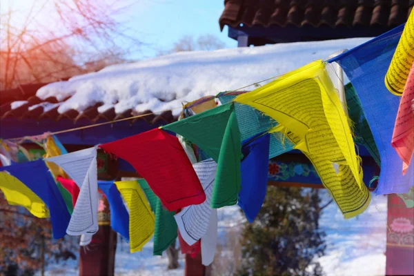 Les drapeaux de prière bouddhistes tibétains flottent dans le vent. Drapeaux tibétains colorés illuminés par le coucher du soleil . — Photo