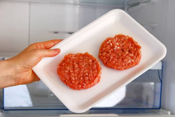 Rauwe kip Burger in container is op plank in open koelkast. Ingrediënt voor het koken van vleesgerechten. Gekookt vlees. — Stockfoto