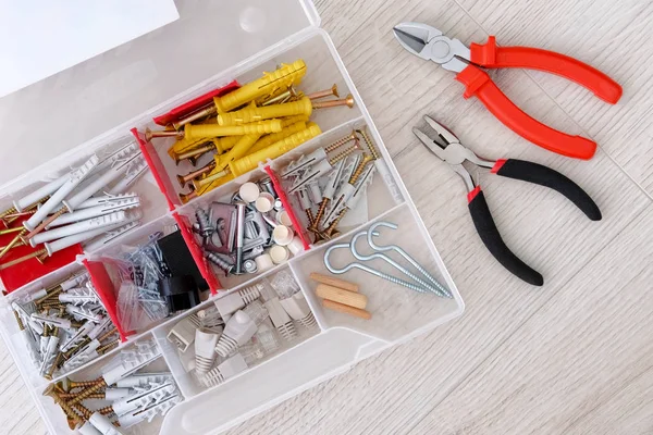 特別なツールで家の中で修理。白い木製の背景に赤い特別なツール、部品やペンチ、クローズアップ. — ストック写真