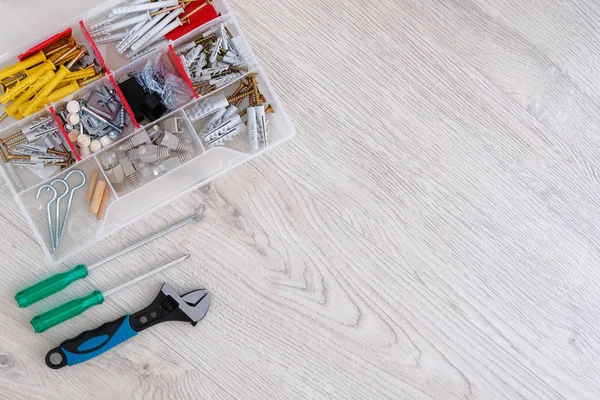 Platt låg av verktyg, delar och skruvmejslar på vit trä bakgrund, närbild. Reparation i hemmet eller lägenhet med specialverktyg. Kopiera utrymme. — Stockfoto