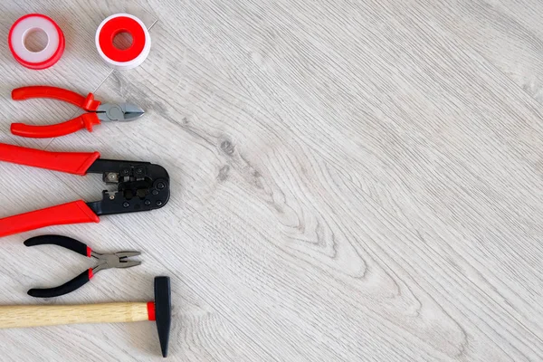 Platt låg av verktyg, delar, hammare och tång på vit trä bakgrund, närbild. Reparation i hemmet eller lägenhet med specialverktyg. Kopiera utrymme. — Stockfoto