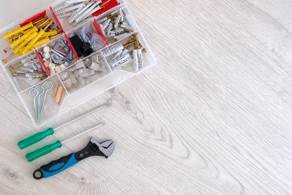 Flat lay of box with special tools, parts and screwdrivers, closeup. Do it yourself. Diy repairs. Copy space. White wooden background. — Stock Photo, Image