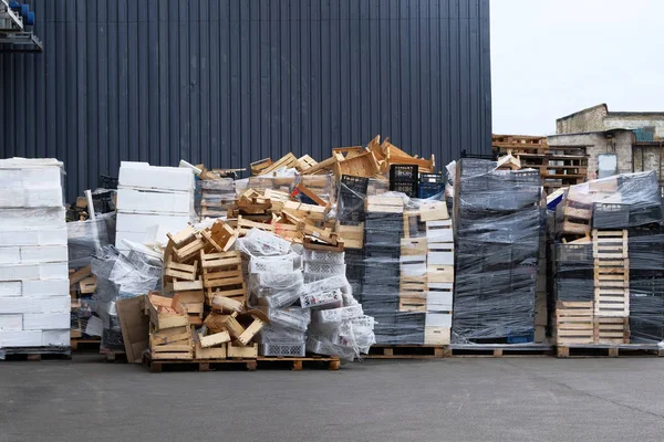 Pilhas de caixas de madeira e plástico no armazém no pátio da loja. Caixas e recipientes para produtos de transporte por caminhão. Carga e transporte nas lojas . — Fotografia de Stock