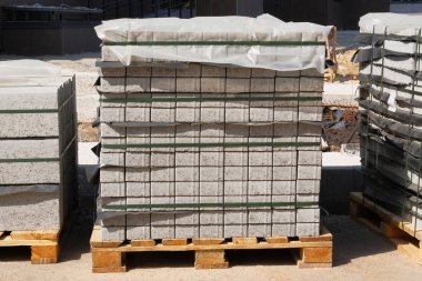 Şantiyede gri tuğla yığını. Bina ve yapıların inşası için yapı malzemeleri. İnşaat Malzemeleri.