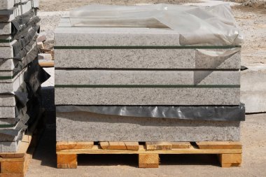 İnşaat Malzemeleri. Şantiyede gri tuğla ve levha yığını. Bina ve yapıların inşası için yapı malzemeleri.