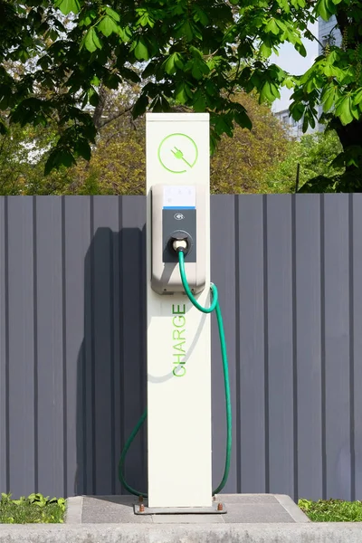 Elektrik şarj istasyonu. Çevre dostu ulaşım konsepti. Şarj istasyonunun önünde oturum açın. Dikey görünüm.