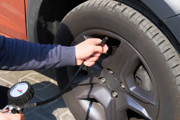 Araba servisi. Erkek el araba lastikleri basınç kontrol eder. Otomatik bakım konsepti.
