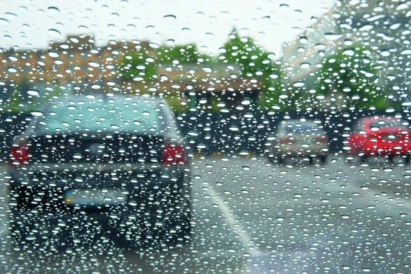 Rainy days. Driving in rain, rainy weather. Rain drops on window.