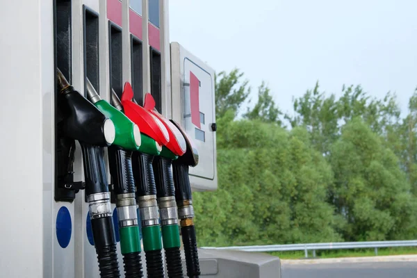 Conceito de gasolina e produtos petrolíferos. Pistolas de combustível vermelho e preto na estação de carburante.Para encher o carro com gasolina. Fechar . — Fotografia de Stock