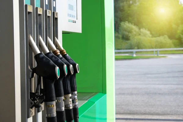 Gasoline and oil products concept. Black fuel pistols on fuel station. Pumping petrol at gasoline pump. Sunlight. — Stock Photo, Image