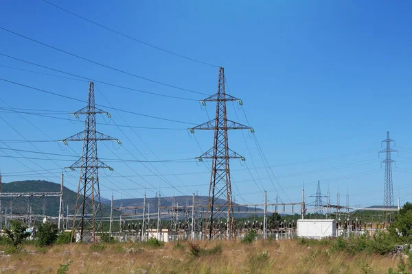 Σταθμός ενέργειας. Στύλους ηλεκτρικής ενέργειας υψηλής τάσης στα βουνά. Πυλώνες μετάδοσης ηλεκτρικής ενέργειας. — Φωτογραφία Αρχείου