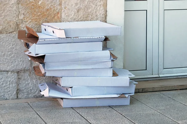 Caixas de pizza vazias são dobradas para posterior triagem e processamento. O cartão e os resíduos de papel são recolhidos e embalados para reciclagem. Reciclagem urbana . — Fotografia de Stock