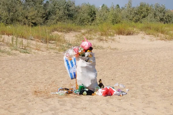 Garbage bags on the sea coast. Garbage in sand beach. Dumpsters bag full with garbage. Waste for recycle.