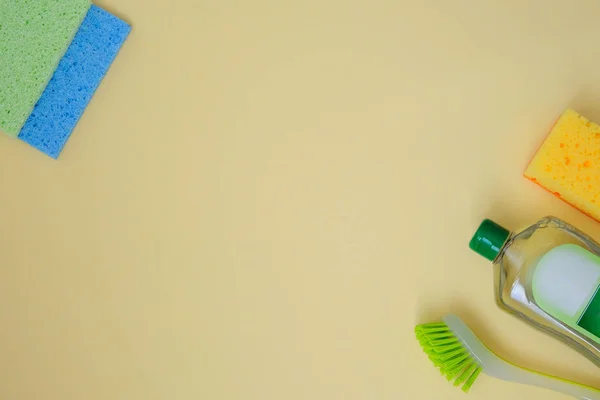 Cleaning products on yellow background. Micro fiber, sponges and brush. leaning accessories. Top view. Copy space.