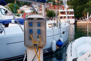 Akdeniz 'de deniz kıyısındaki teknelere elektrik vermek için elektrik prizleri. Tekneler için şarj istasyonu. Yatay çerçeve.