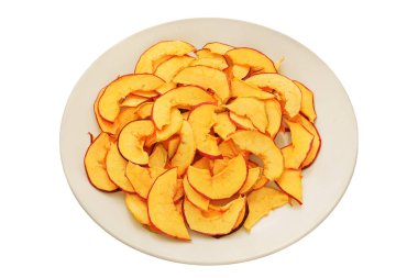 Ev yapımı aperatif. Beyaz arka planda izole edilmiş beyaz seramik tabakta kurumuş elmalar. Çeşitli kuru meyve dilimleri. 