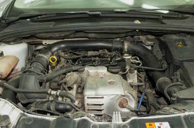 Kaputu açık beyaz üç silindirli bir benzin vagonunun motor kompartımanı.