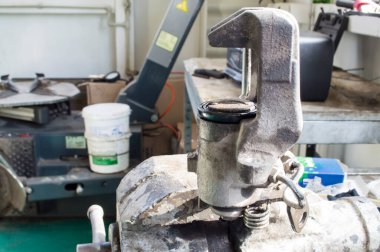 Arabadan çıkarılan fren kalibresi araba tamirhanesinde mengeneye yerleştirildi.